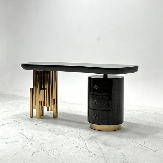 Antigua sculptural luxury desk featuring gold tubular legs and serpentine handles
